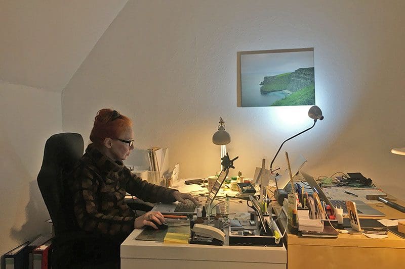 Die Autorin am Schreibtisch mit Blick auf die Steilküste Irlands