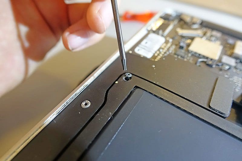 Die Schrauben des MacBook Akkus vorsichtig lösen