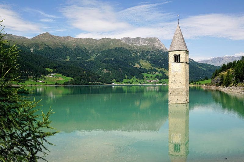 Die Kirche von Graun steht im Vinschgau unter Wasser, entdeckt mehr über die wahre Geschichte..