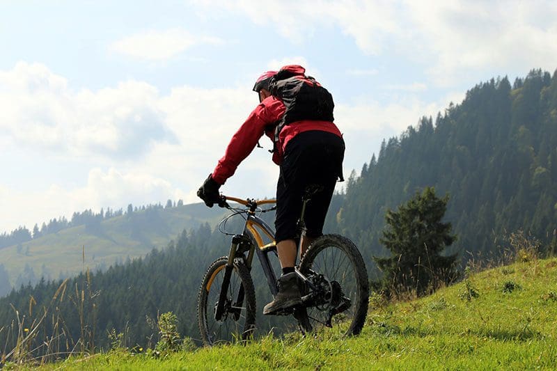 Ein Mountainbiker fährt einen Berg in den Alpen hinunter