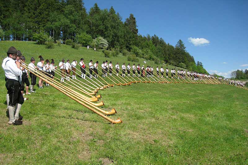 Tradition pur im Allgäu: die Alphornbläser aus dem Allgäu zeigen den urigen Klang auf einem Berg.