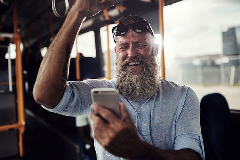 Busfahrender Mann hört Musik während der Fahrt