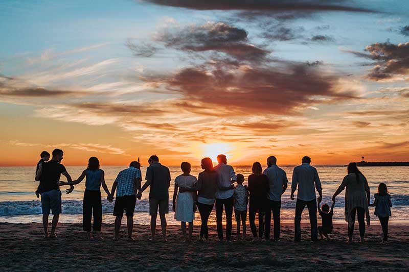 Familien am Strand beim Sonnenuntergang