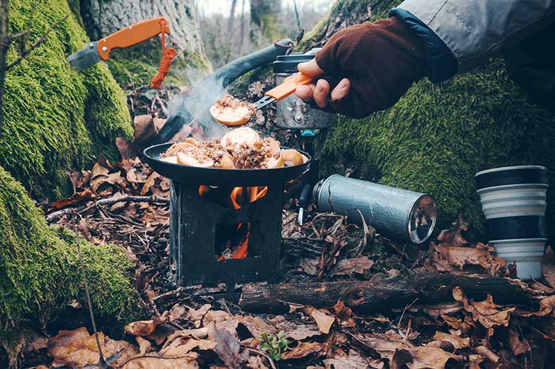 Survival Messer und Kocher im Wald verwenden