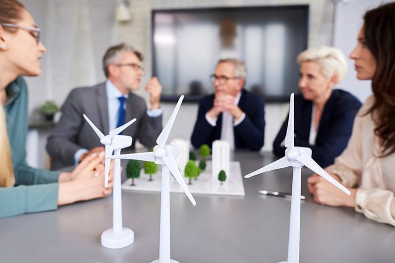 Unternehmer sitzen bei einem Windkraft Meeting
