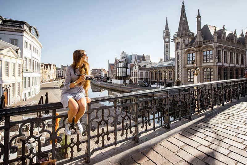 Urlauberin sitzt auf einer Brücke in Gent