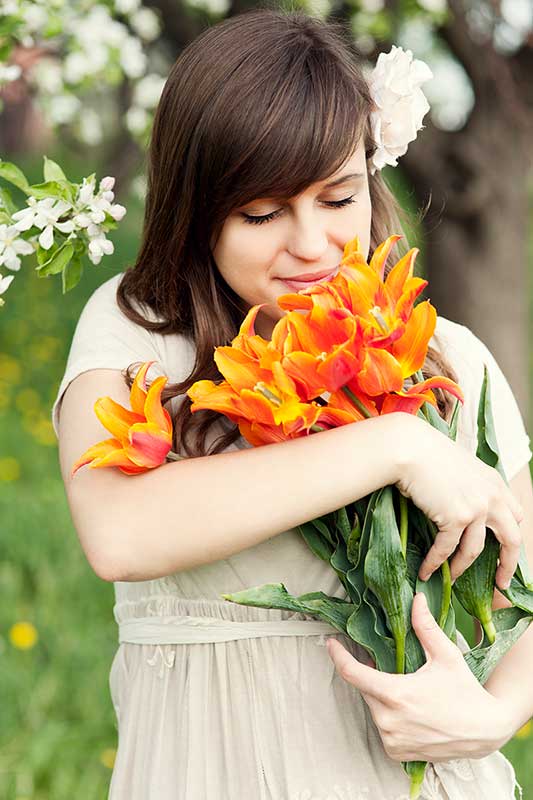 Frau hält einen Blumenstrauß im Arm