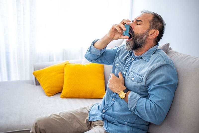 Asthmatiker sitzt auf einer Couch