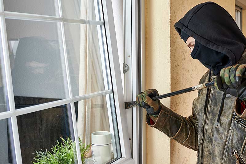 Einbrecher vor einem Fenster