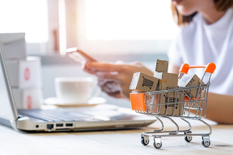 Businessfrau mit Shoppingcard und Einkaufswagen