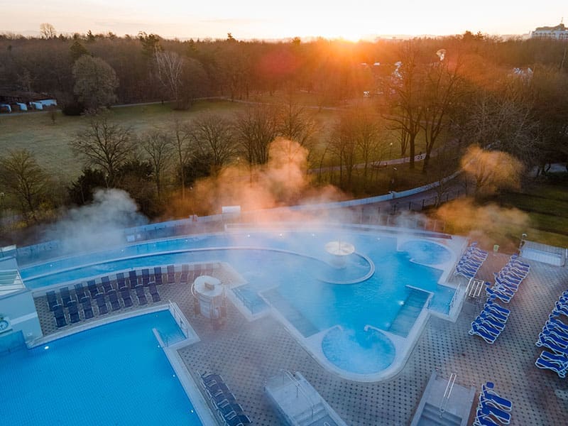 Europa-Therme_Außenbecken-Strömungskanal-Sprudelliegen-Liegestühle-Sonnenaufgang