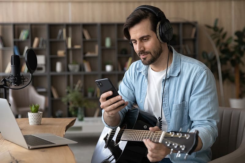 Gitarisst-spielt-Musik-mit-seinem-Smartphone