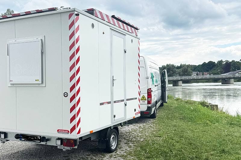 Van-Crafter-am-Fluss-Inn-mit-dem-Anhänger-parkend