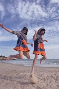 Heiko-und-Franz-springen-im-Poncho-am-Meer-in-Tarragona