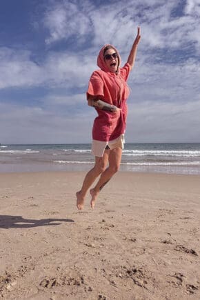 Shania-hüpft-im-Poncho-von-Wave-Hawaii-am-Strand